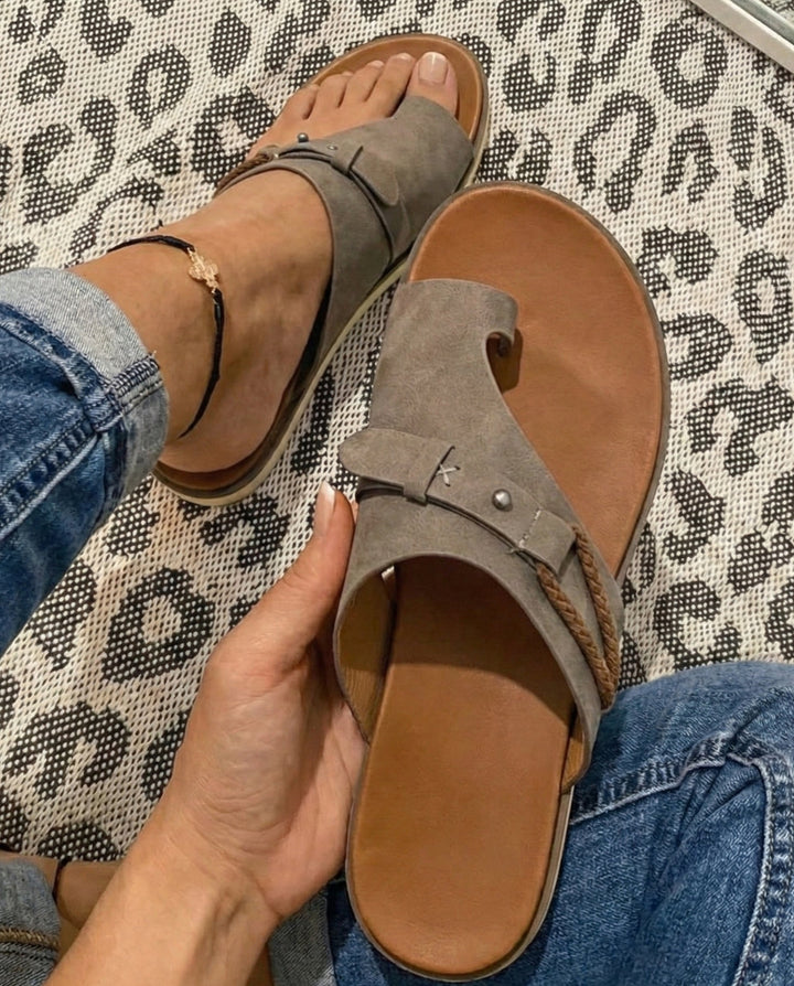 Women's grey toe-loop flat sandal displayed with comfortable cushioned sole