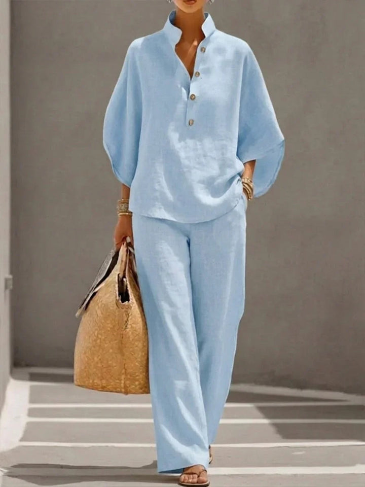 Woman wearing a light blue two-piece outfit with a relaxed fit and long trousers