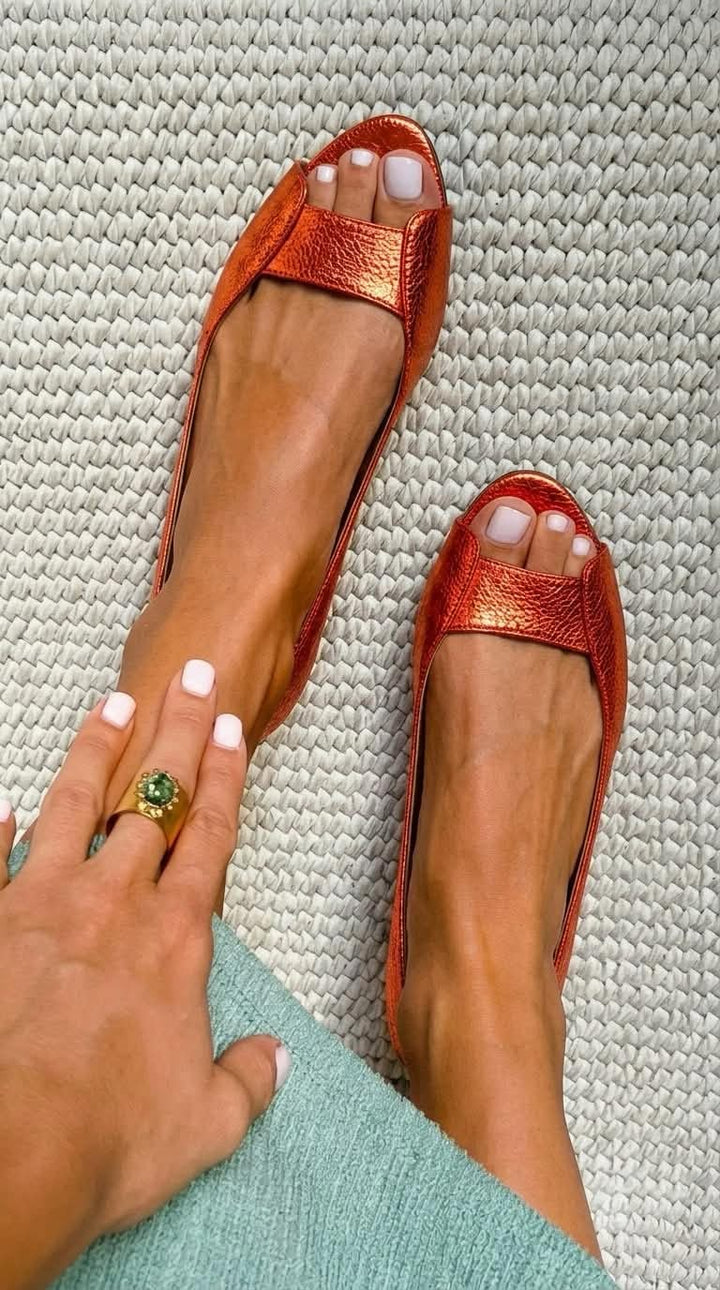 Close-up of comfortable flat sandals for women featuring metallic upper design