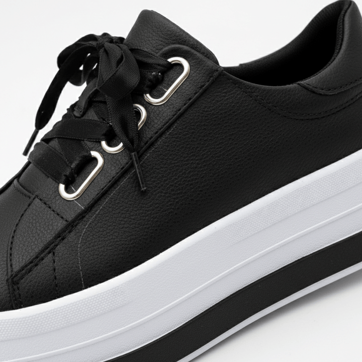 Close-up of metallic eyelets and laces on stylish women's fashion sneakers