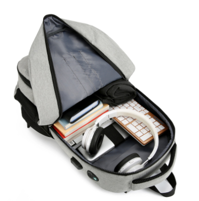 Top view of open grey travel backpack showing spacious main compartment and electronic accessories