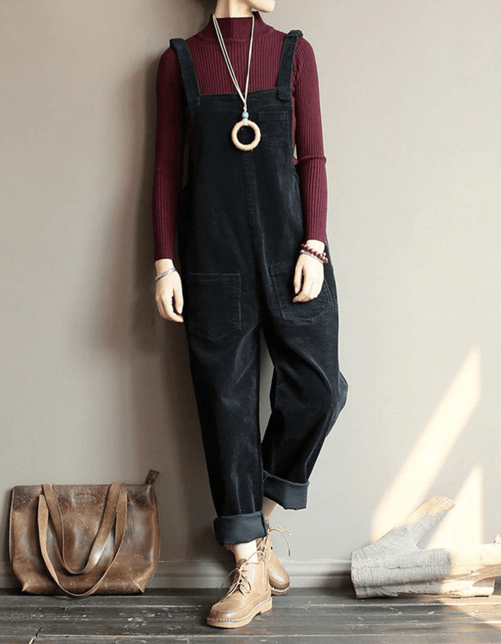 Woman wearing a black relaxed pocket dungaree jumpsuit paired with a burgundy top