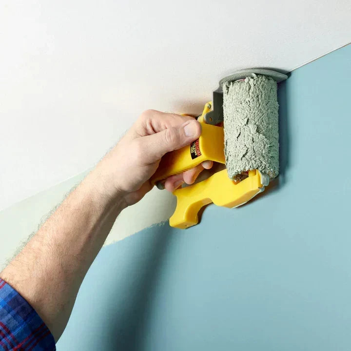 Person painting a wall corner near the ceiling with a specialty edge roller
