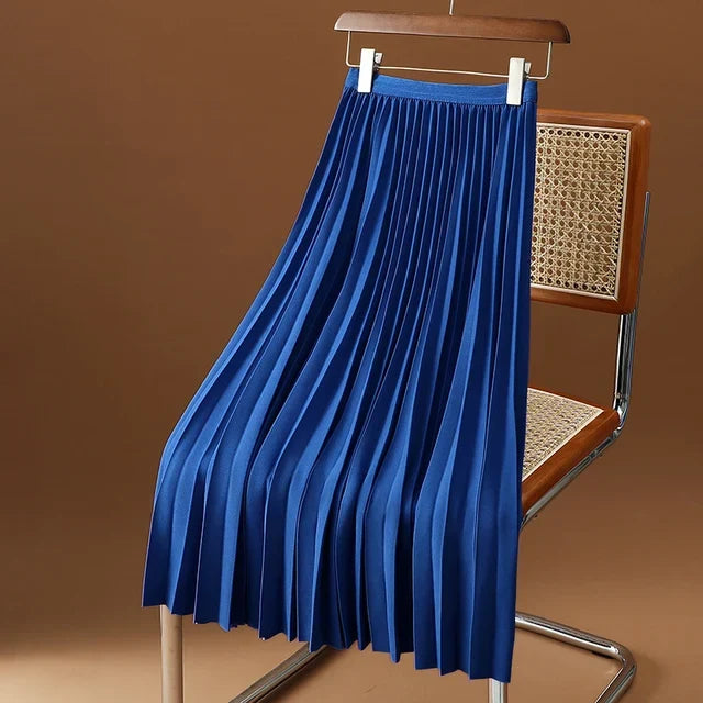 Blue pleated midi skirt hanging on a wooden hanger