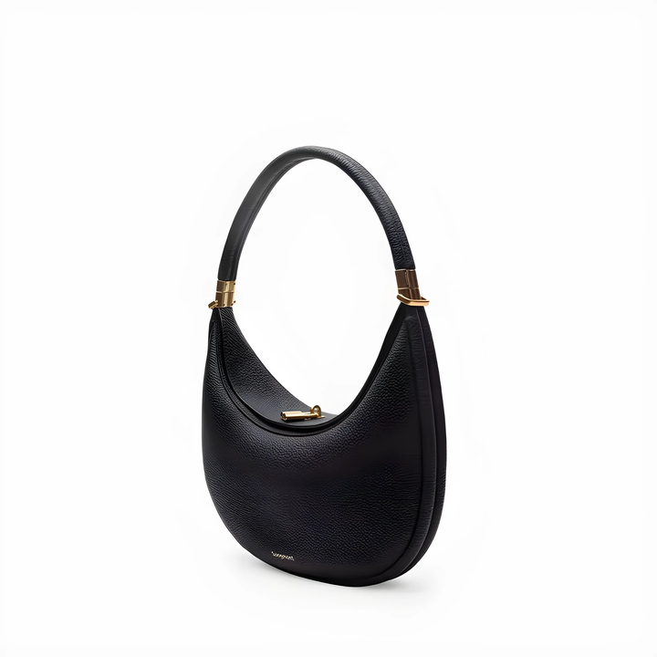 Stylish crescent crossbody handbag worn by a woman, showcasing its trendy shape and design.
