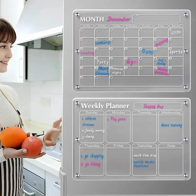 Clear acrylic monthly and weekly magnetic planner boards mounted on a refrigerator