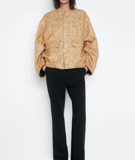 Full length view of a model wearing the gold jacket and black trousers