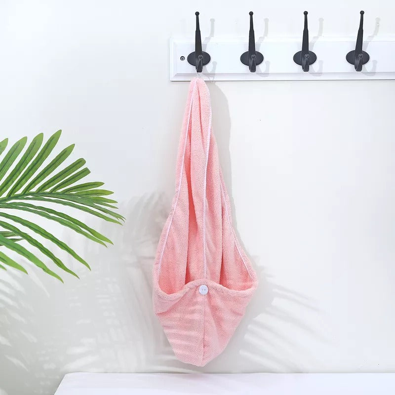 Pink microfibre hair towel wrap hanging on a wall hook