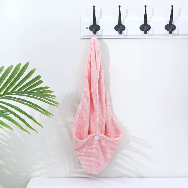 Pink microfibre hair towel wrap hanging on a wall hook