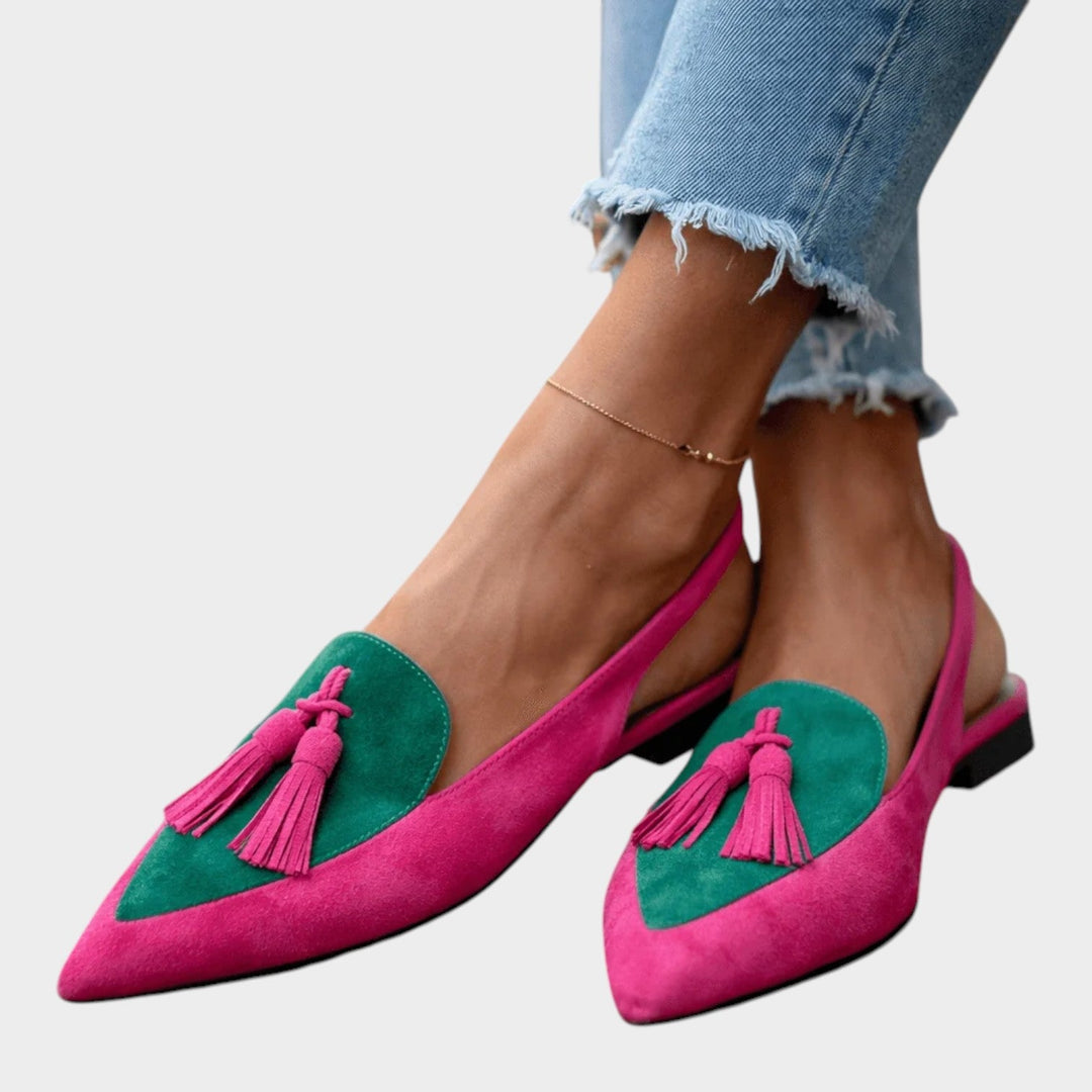 Detailed look at the soft upper material and bohemian tassel accents on flat sandals.