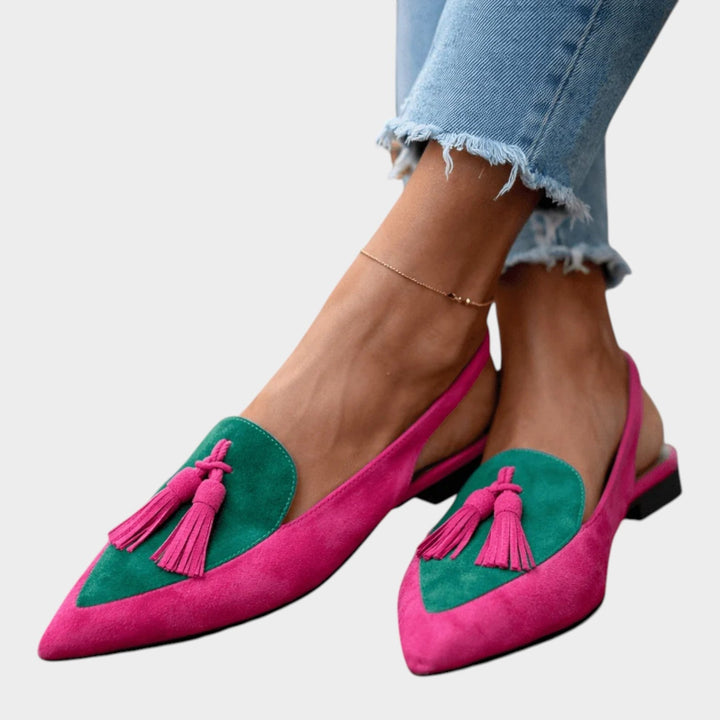 Detailed look at the soft upper material and bohemian tassel accents on flat sandals.