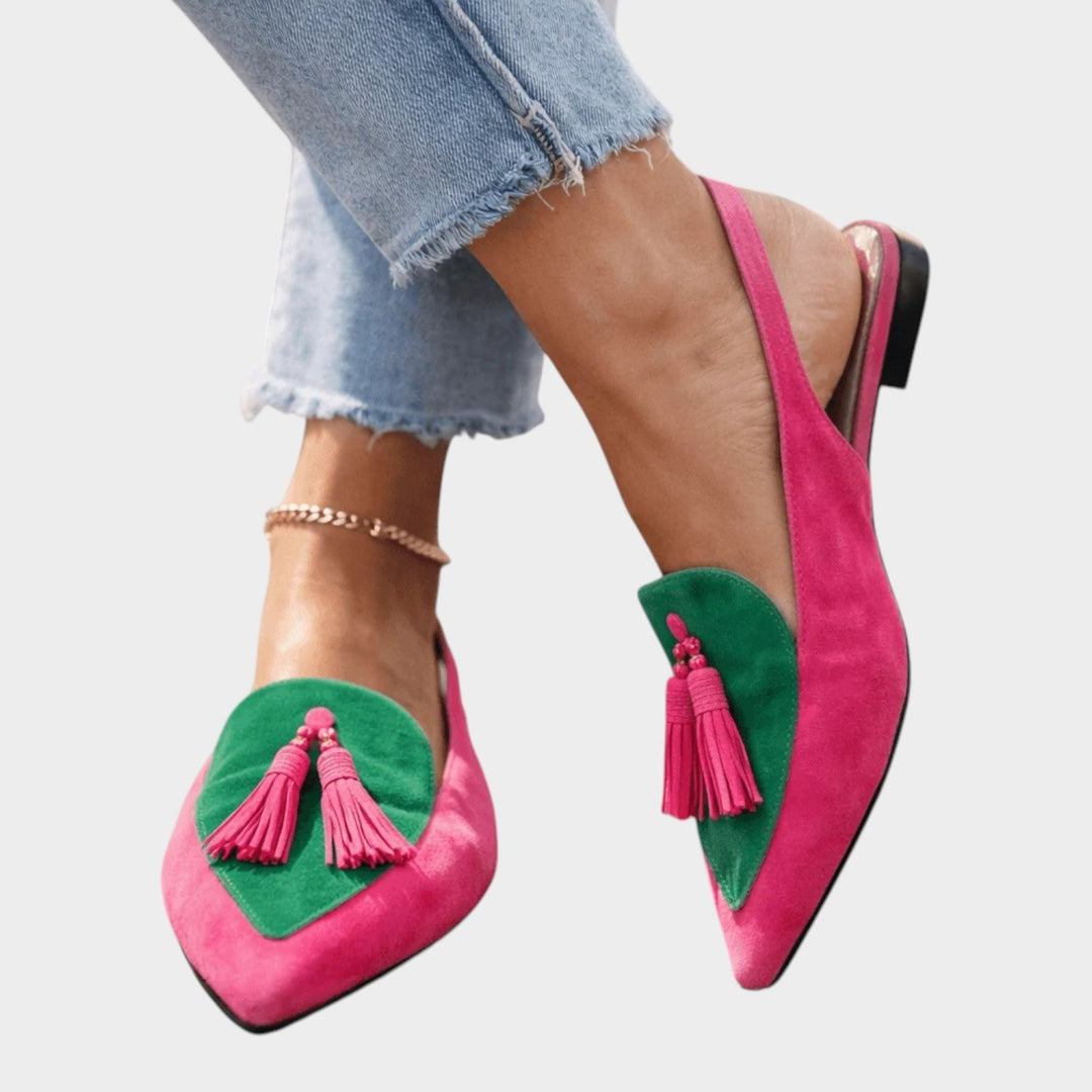Angle shot of slingback flat sandals featuring playful fringe details for warm weather wear.