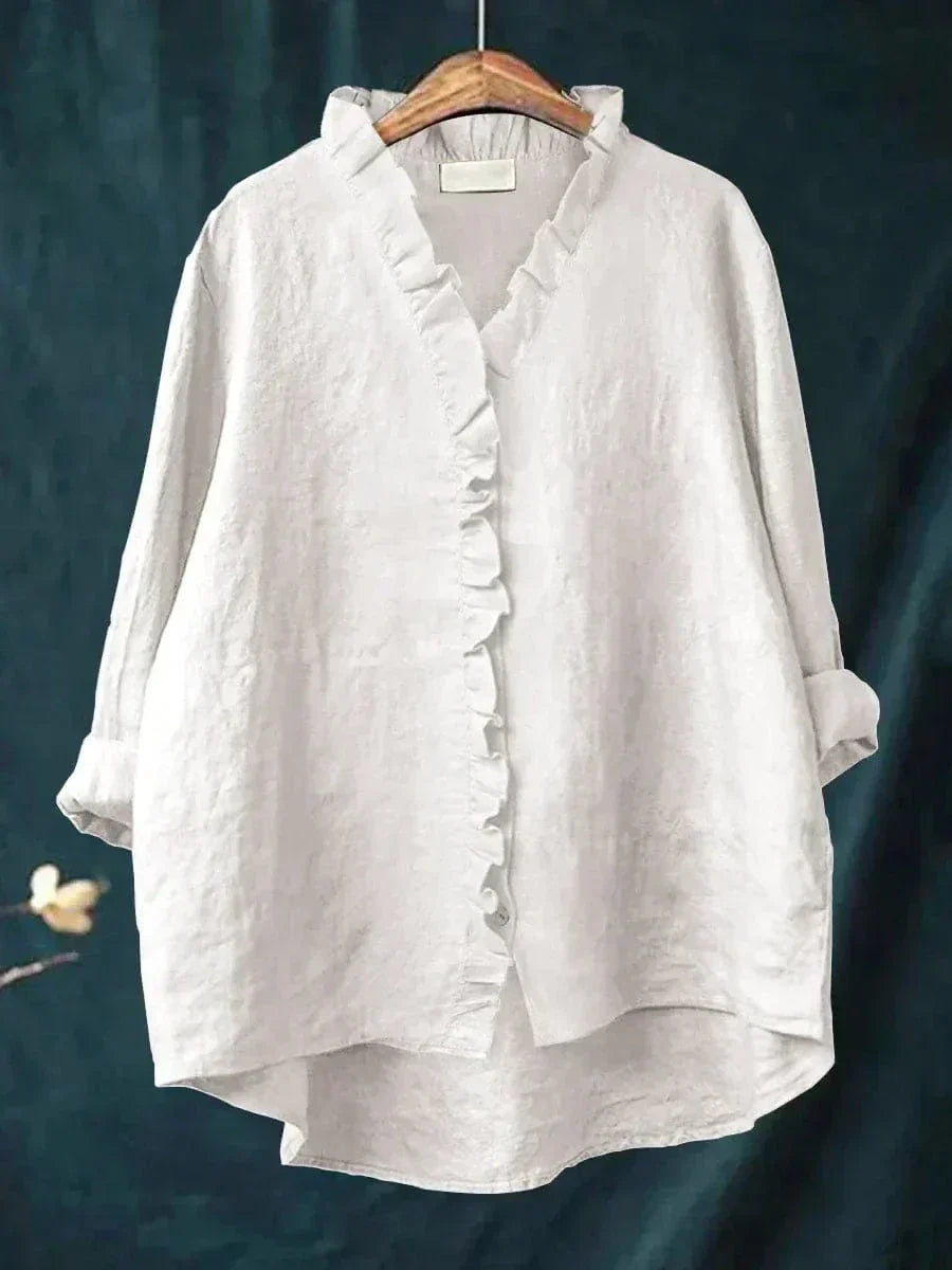 White women's ruffle v-neck summer blouse hanging on a wooden hanger