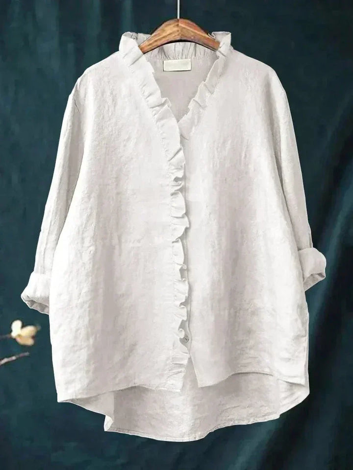White women's ruffle v-neck summer blouse hanging on a wooden hanger