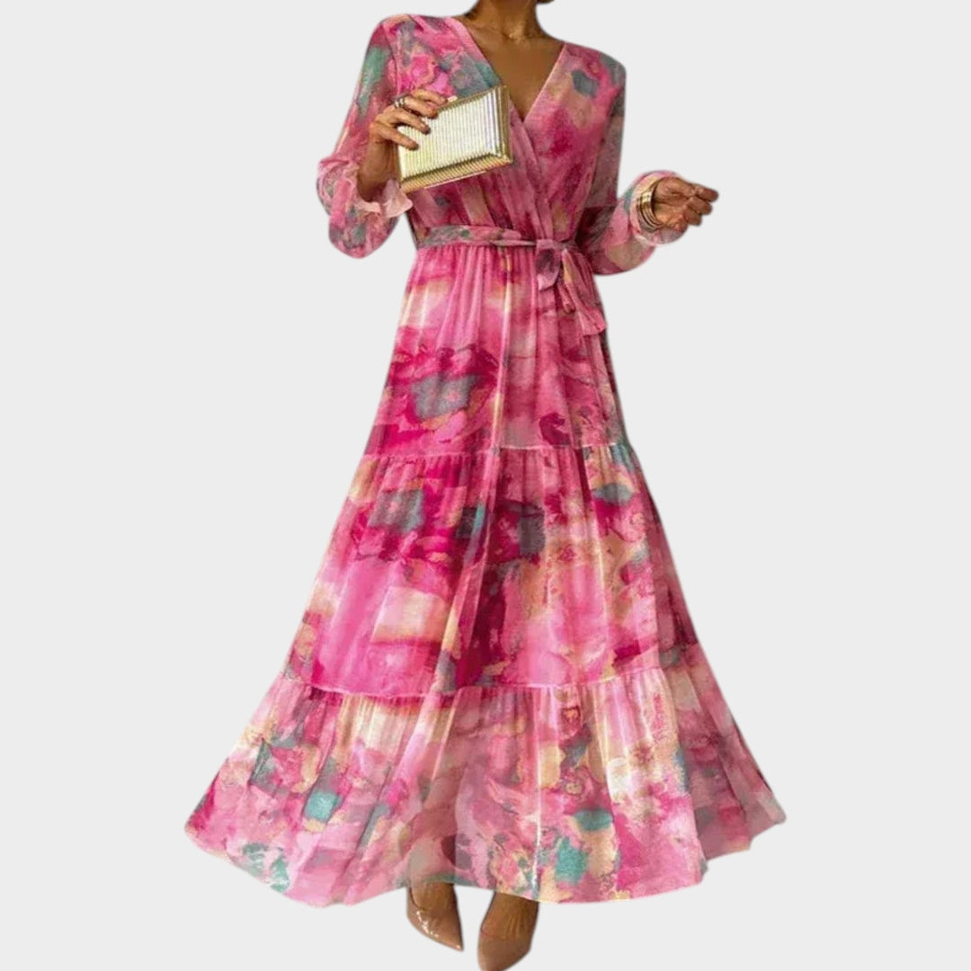 Women wearing a pink floral midi dress with V-neck and tiered hem holding a gold clutch