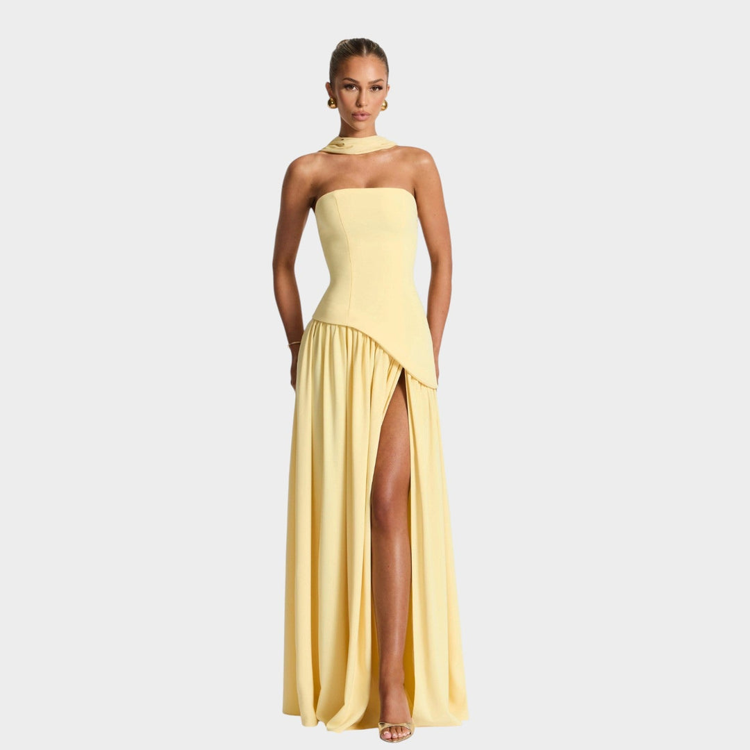 Model wearing yellow strapless maxi dress with corset bodice and front slit