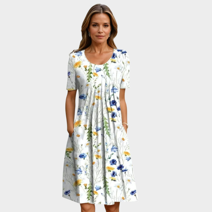 Woman wearing a white midi dress with yellow and blue floral print