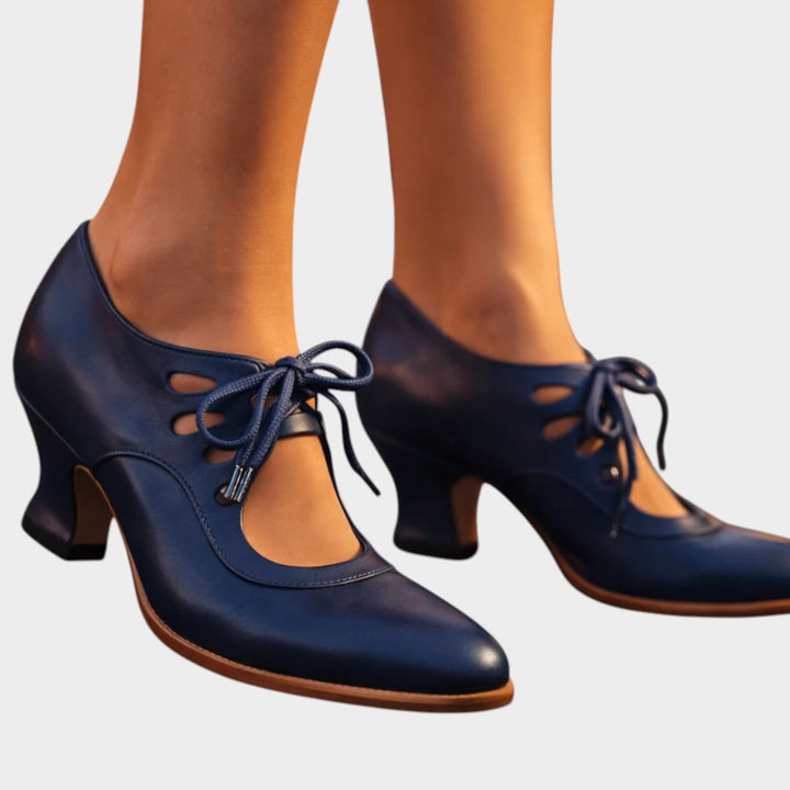 Close-up of women's blue lace-up mid-heel shoes worn on feet
