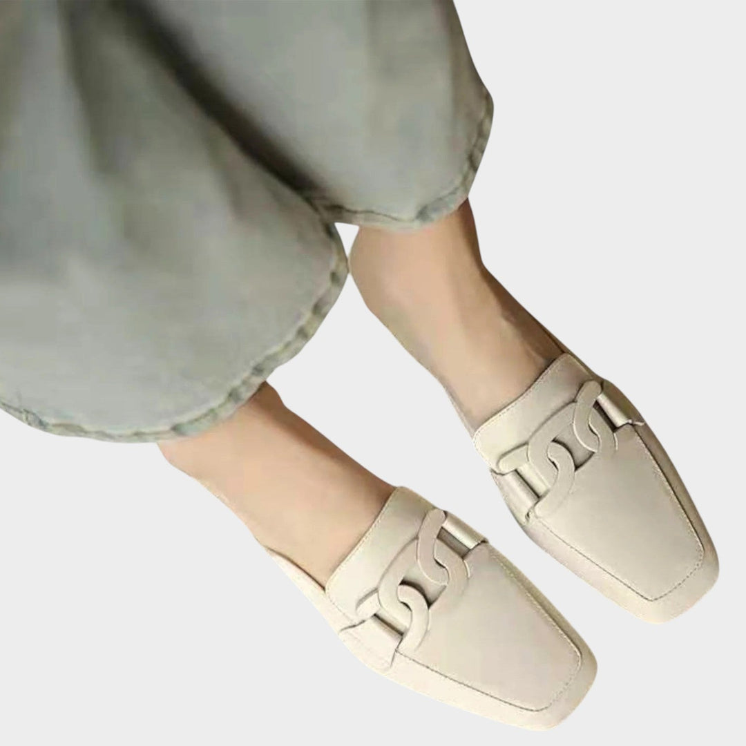 Top-down view of beige slip-on heeled loafers on a neutral background