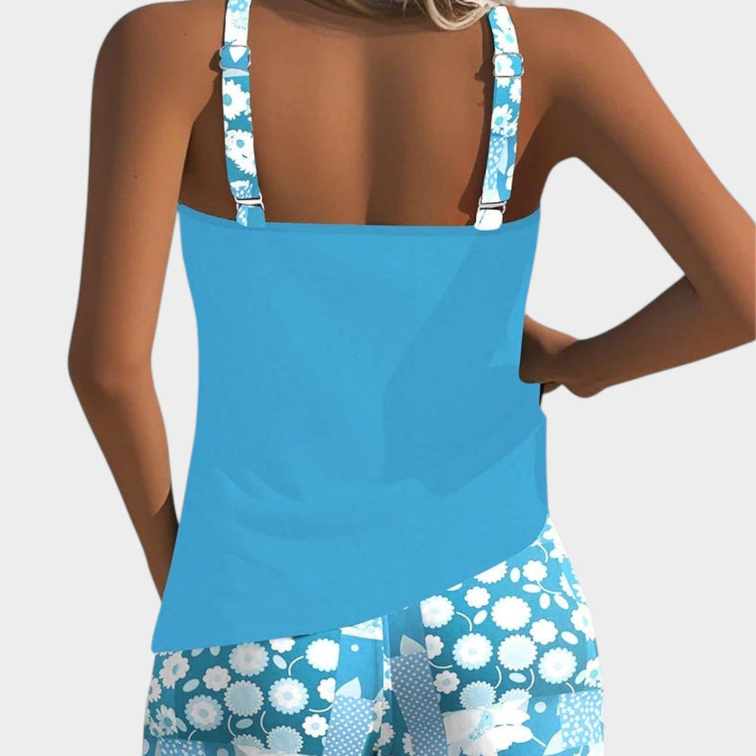 Back view of woman wearing a bright blue tankini top with printed straps