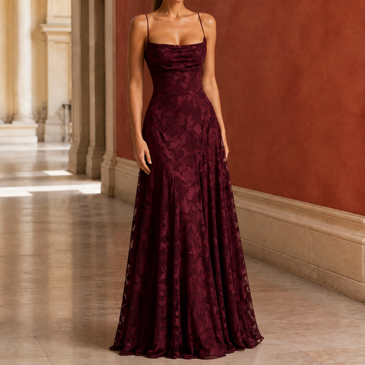 Woman wearing a burgundy draped cowl maxi dress with floral texture in a hallway