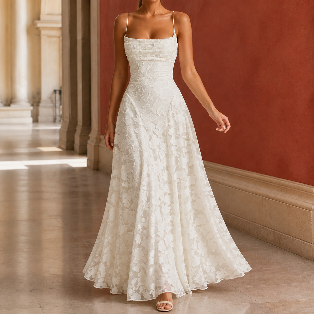 Woman wearing an ivory draped cowl maxi dress with floral texture in a hallway
