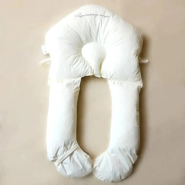Baby head and body support pillow laid flat on nursery bed