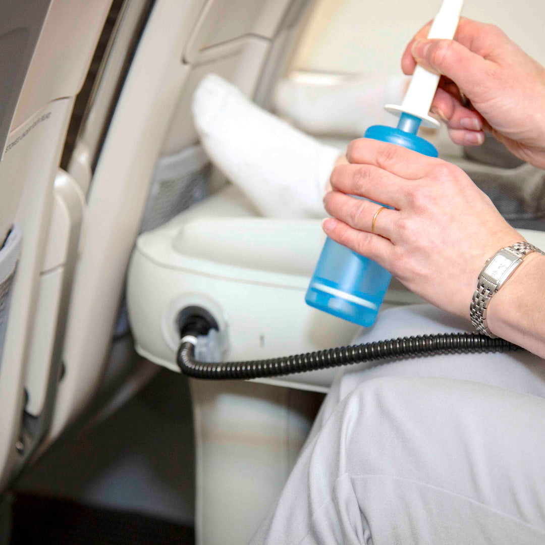 Parent using a hand pump to inflate a kids travel bed on an airplane
