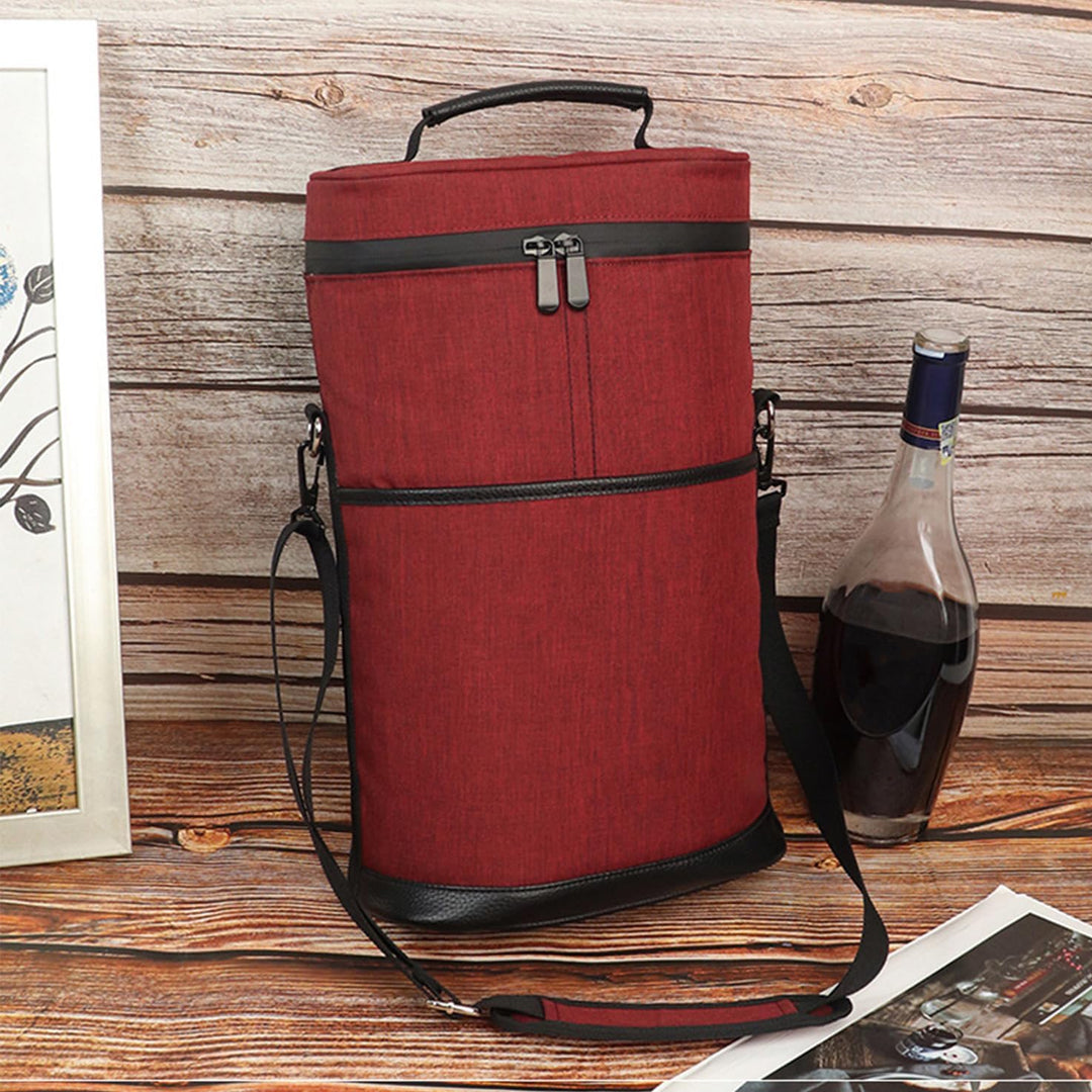 Insulated 2-bottle wine cooler tote bag in red standing on a wooden surface next to a wine bottle