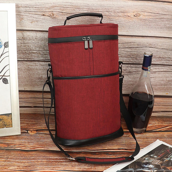 Insulated 2-bottle wine cooler tote bag in red standing on a wooden surface next to a wine bottle