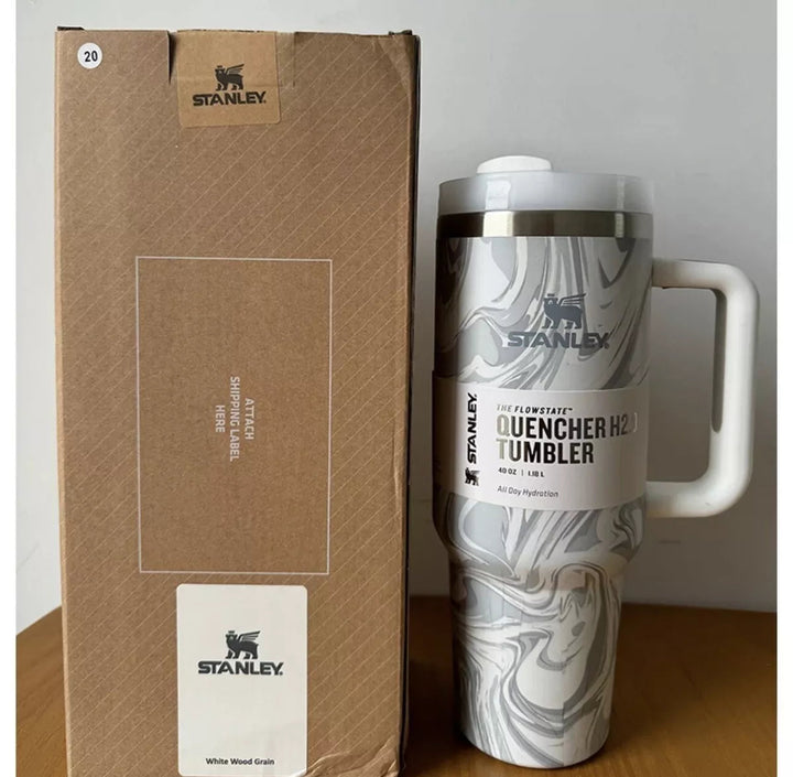 Insulated travel mug with handle resting on a flat surface