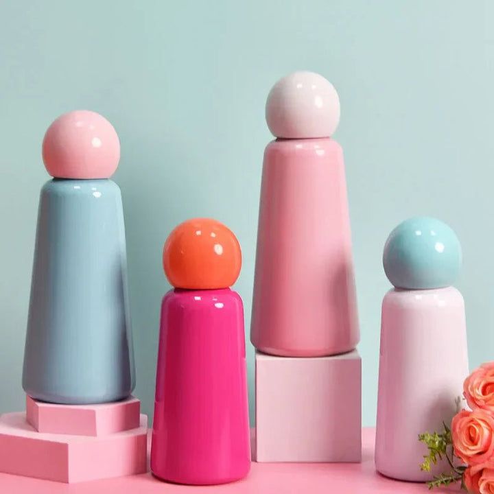 Colorful insulated water bottles with spherical lids displayed on pink and white stands