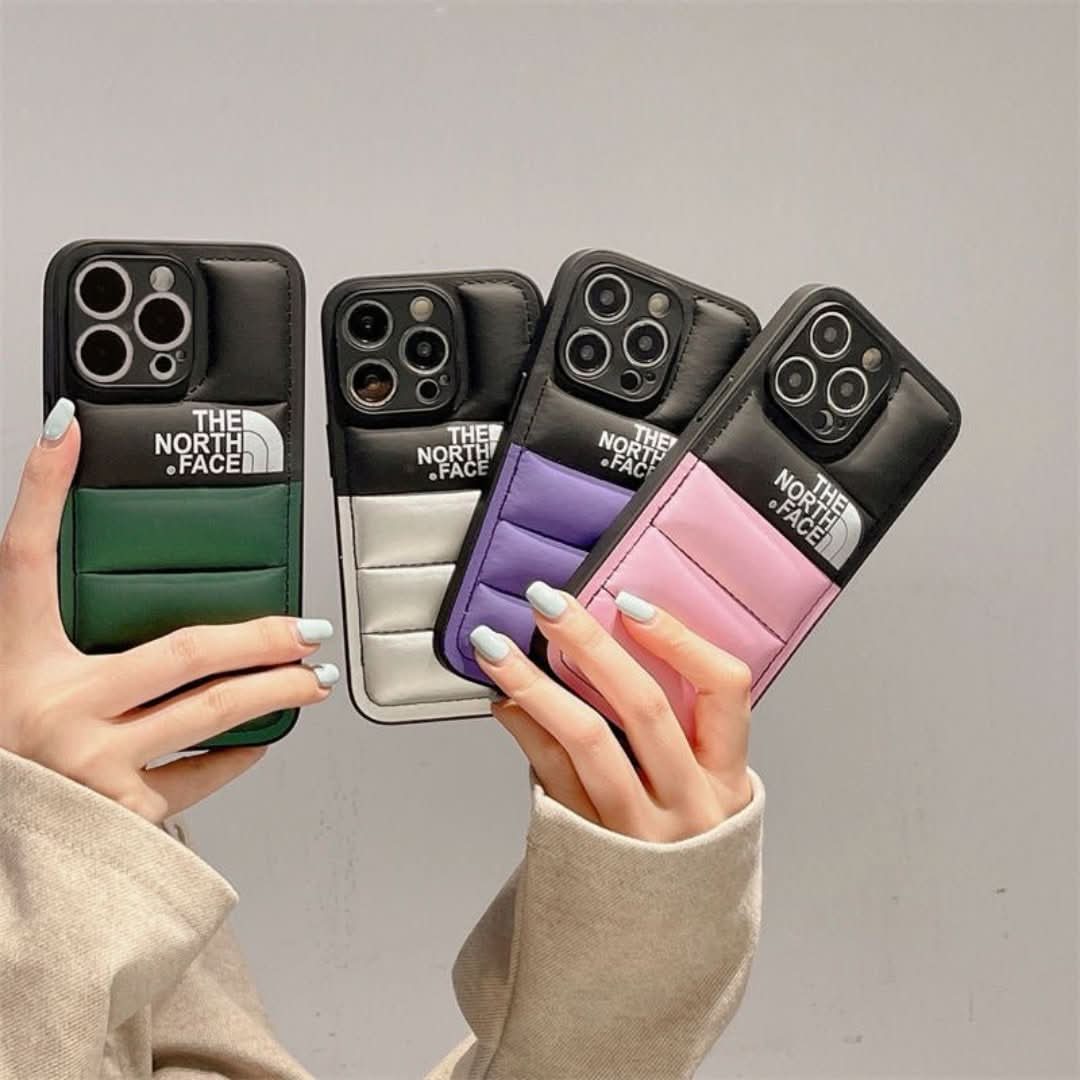 Hands holding multiple colorful puffer design iPhone cases in green, white, purple, and pink.