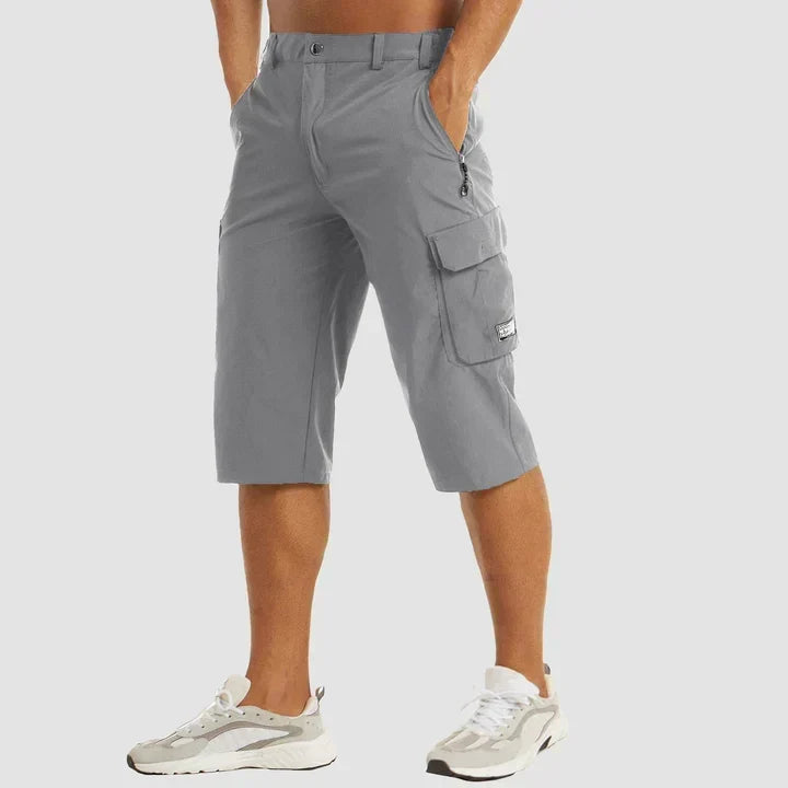 Man wearing grey relaxed cropped cargo shorts with utility pockets