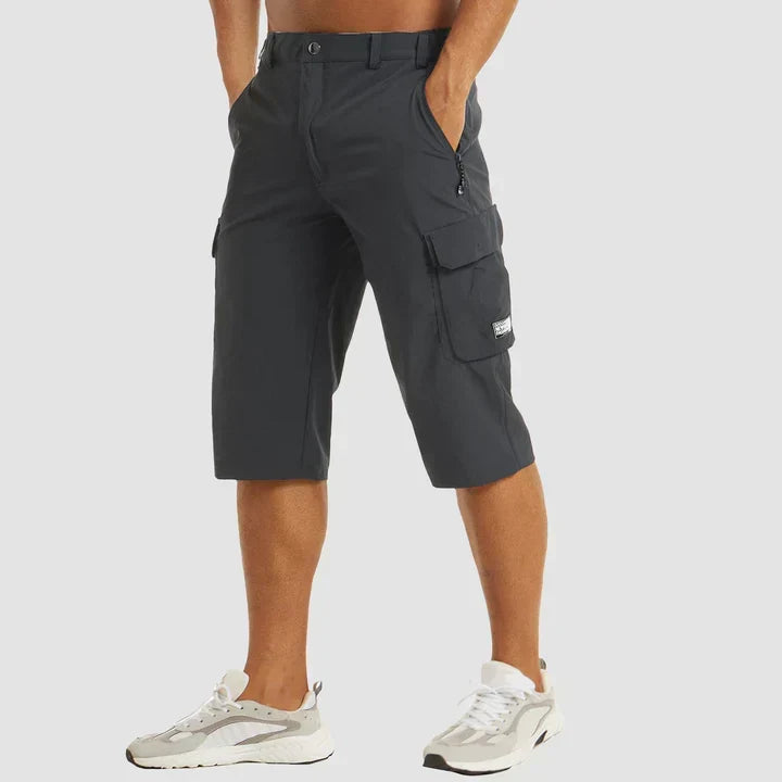 Man wearing dark grey relaxed cropped cargo shorts with utility pockets