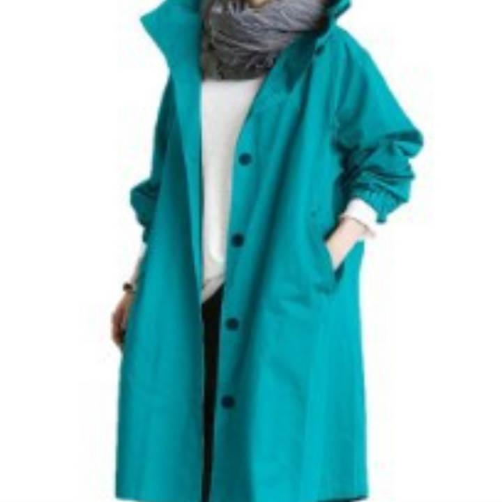 Woman wearing a vibrant green long hooded trench coat with white top