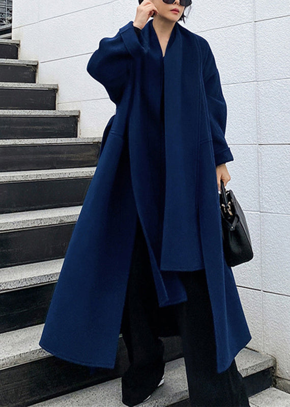 Full-length view of a woman posing in a blue winter coat outdoors