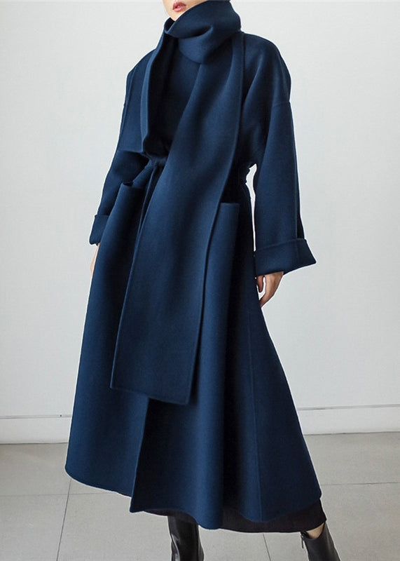 Woman wearing a blue Isabelle tailored winter coat with a matching scarf