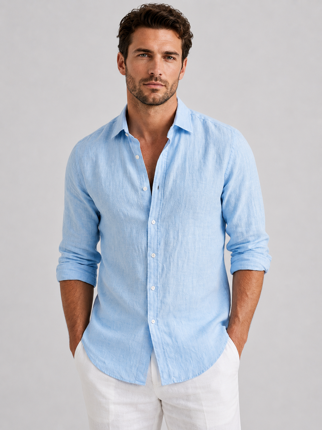 Man wearing a light blue relaxed fit button-up shirt with white trousers
