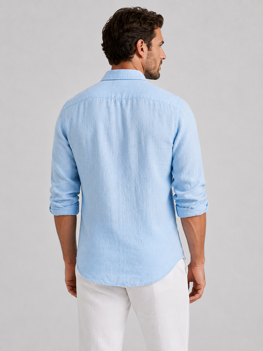 Back view of a man wearing a light blue long-sleeve casual shirt