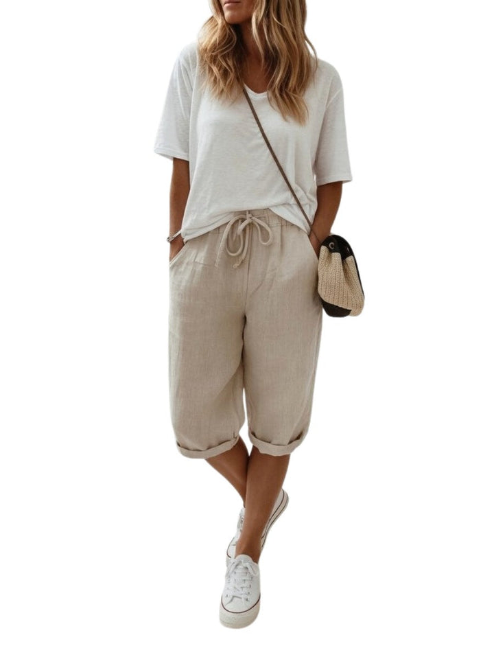 Woman wearing relaxed-fit khaki bermuda shorts with a white t-shirt and sneakers