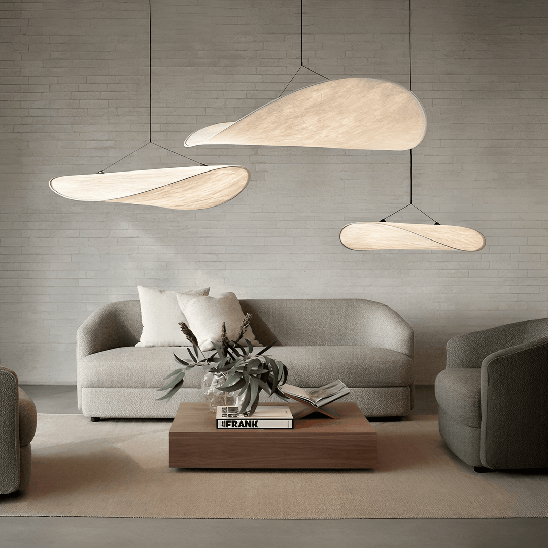 Japandi pendant lamps hanging in a minimalist living room over a sofa