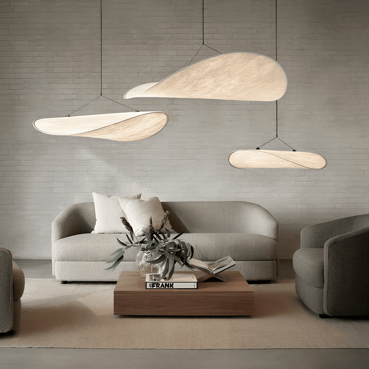 Japandi pendant lamps hanging in a minimalist living room over a sofa