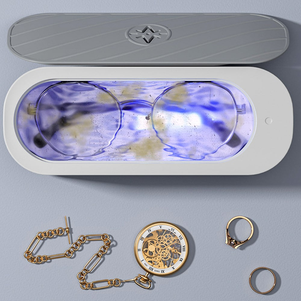 Top view of the ultrasonic cleaner filled with water cleaning glasses and jewelry