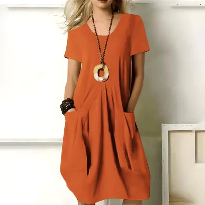 Woman wearing the vibrant orange short sleeve casual dress with side pockets