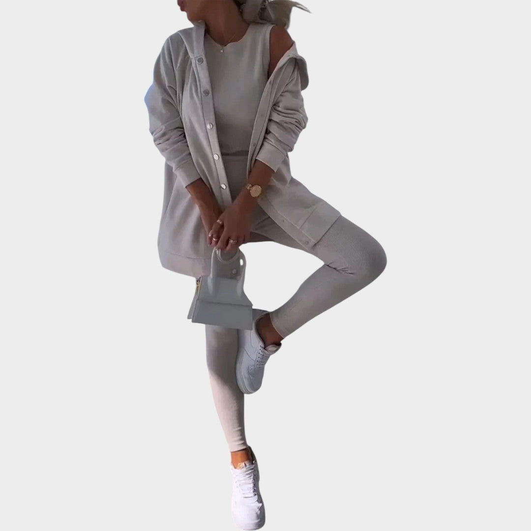 Woman wearing an apricot three-piece lounge set with a handbag and white sneakers