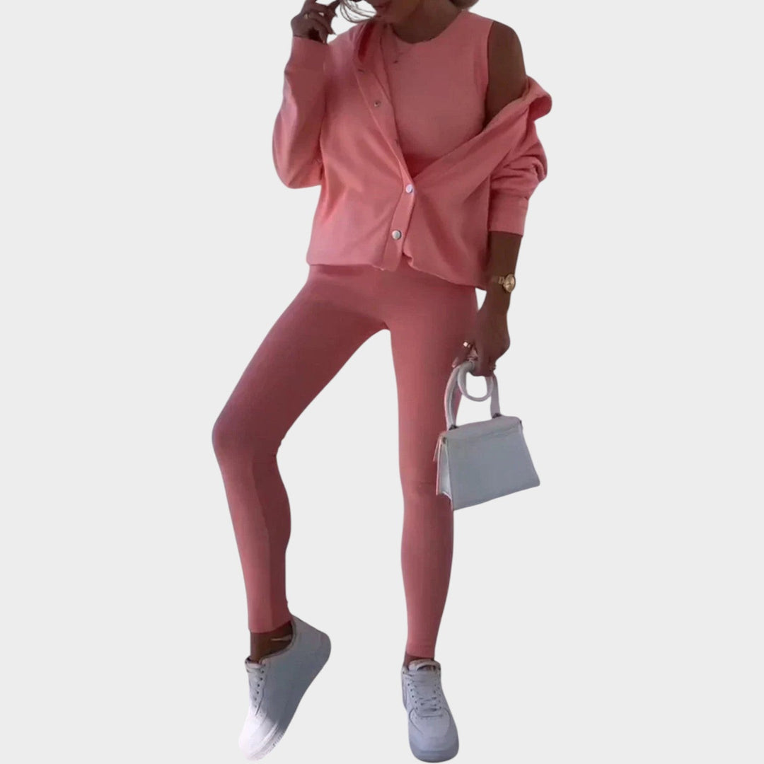 Woman wearing a pink three-piece lounge set with snap buttons and leggings