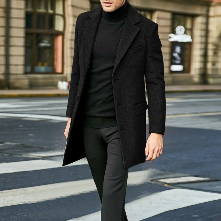 Man walking in a black mid-length notched lapel overcoat