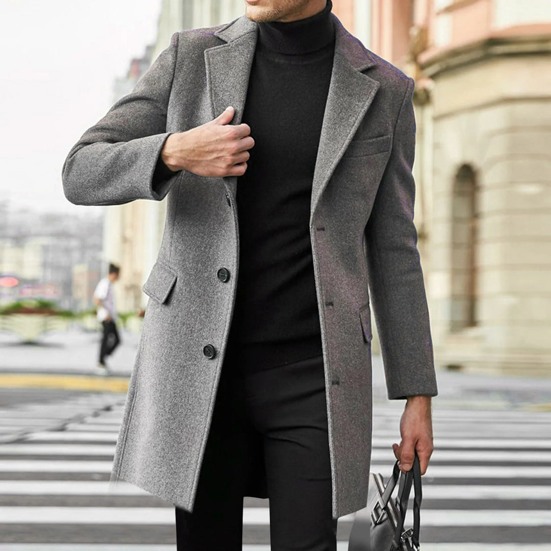 Man wearing a grey mid-length notched lapel overcoat outdoors