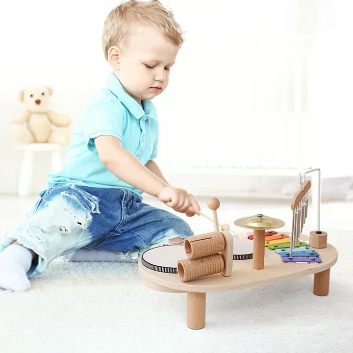 Young child playing with the wooden music station toy indoors